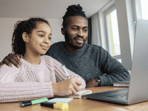 Father helping young student study remotely